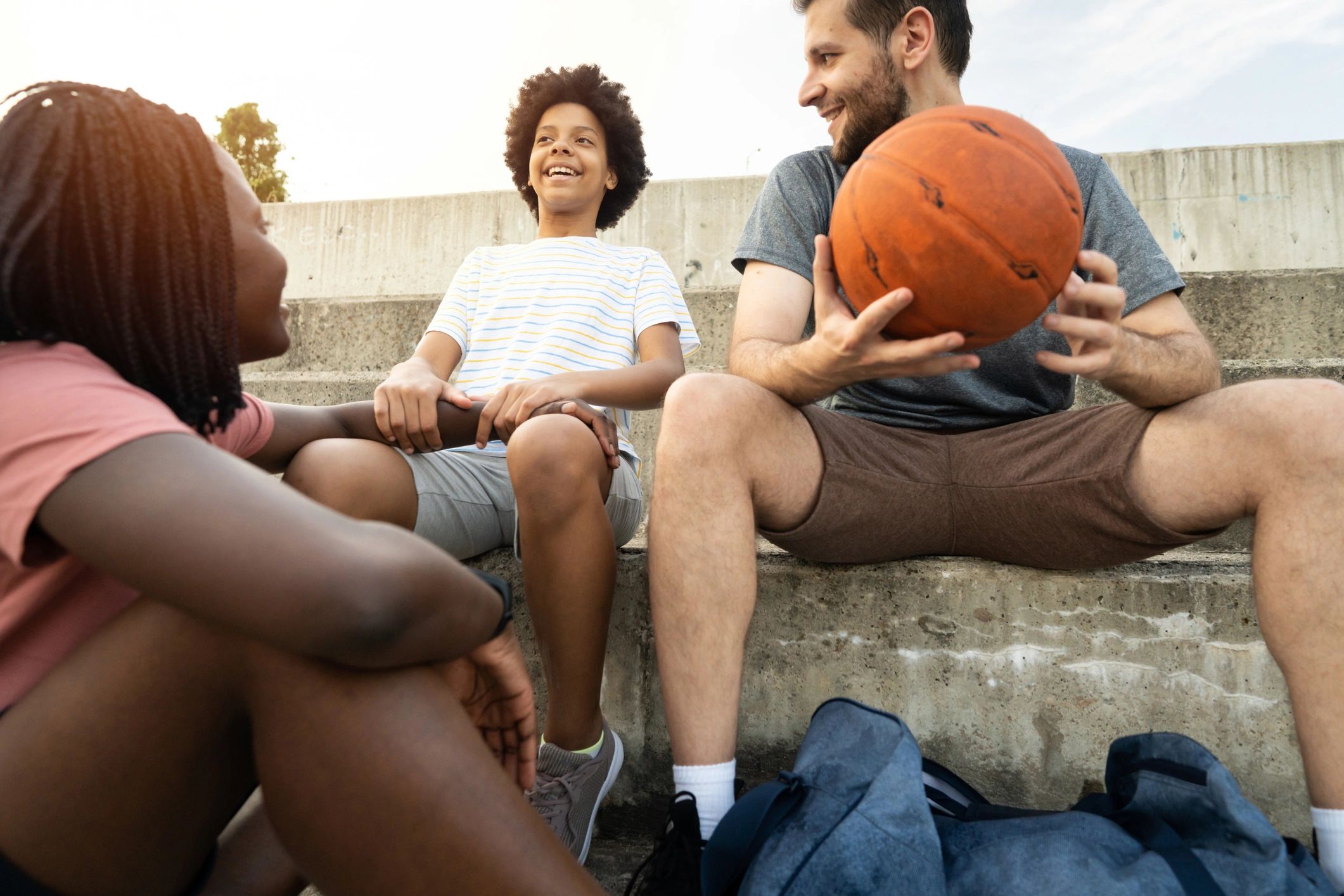Youth and mentors resting after a basketball game