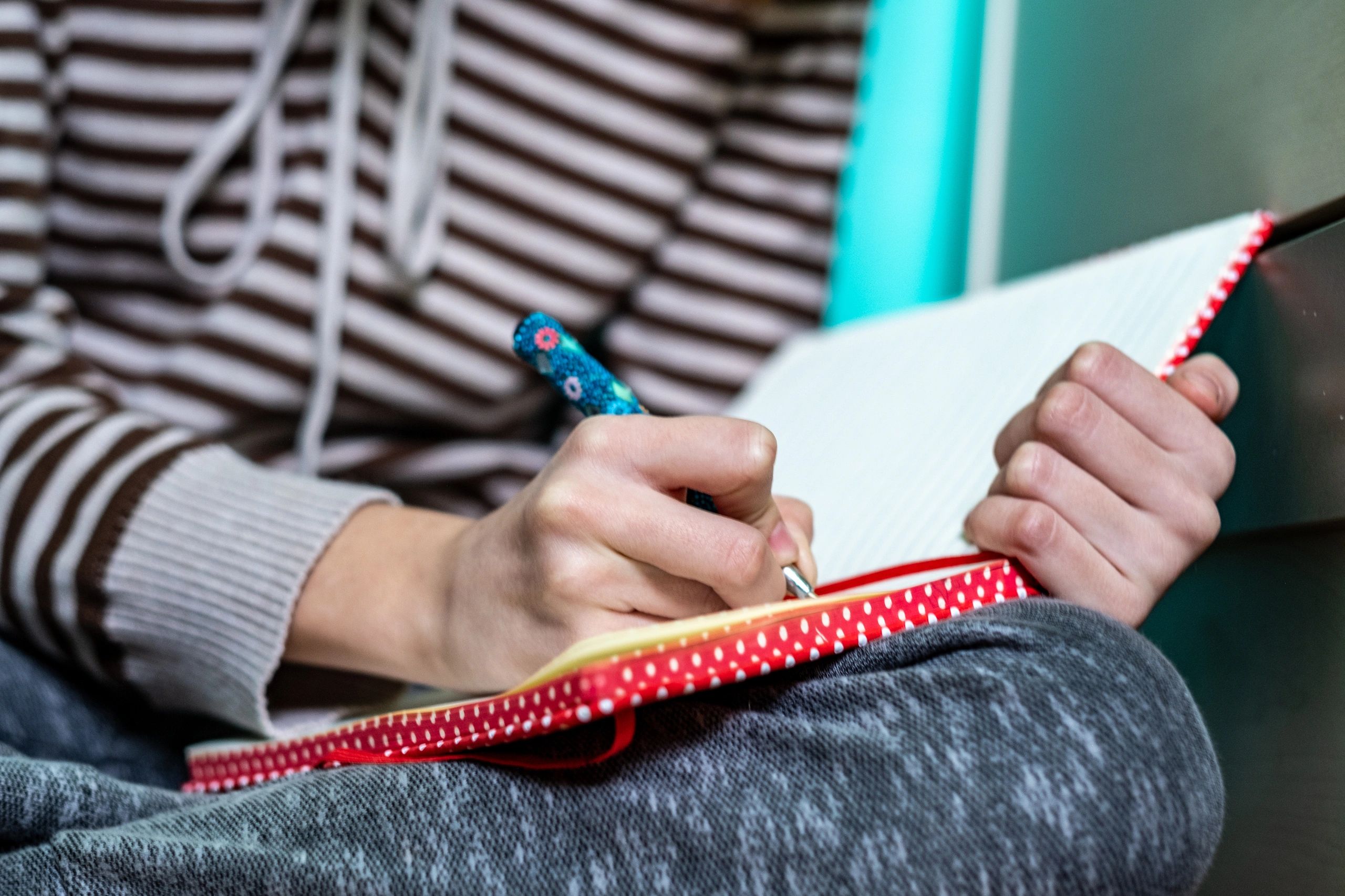 Close-up of hands writing with a pencil