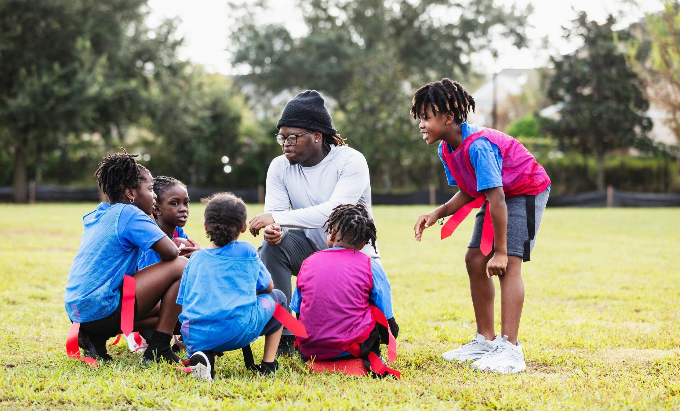 Coach giving a pep talk to a youth team in a huddle