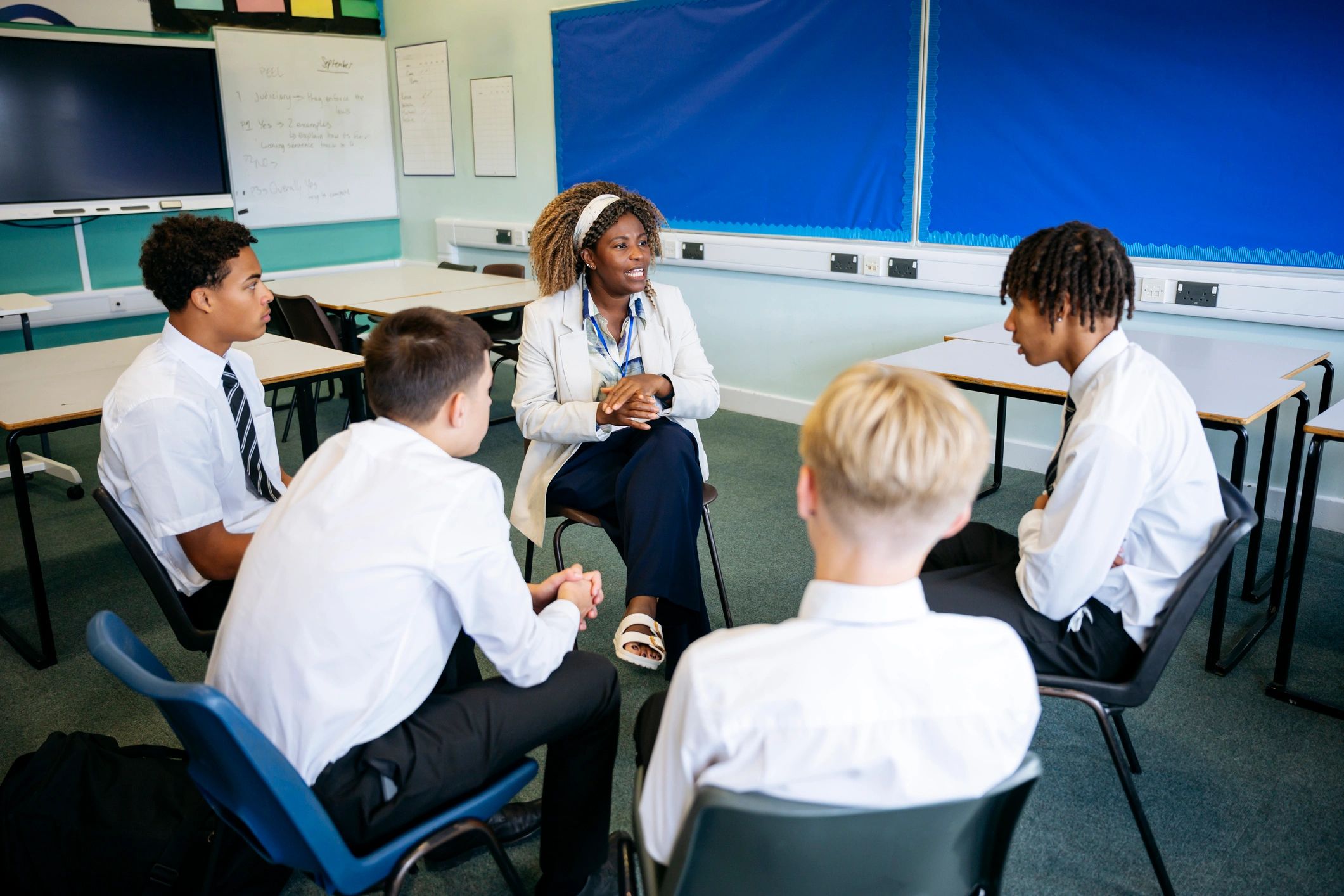 Support worker facilitating a small group mentorship discussion with teenage boys